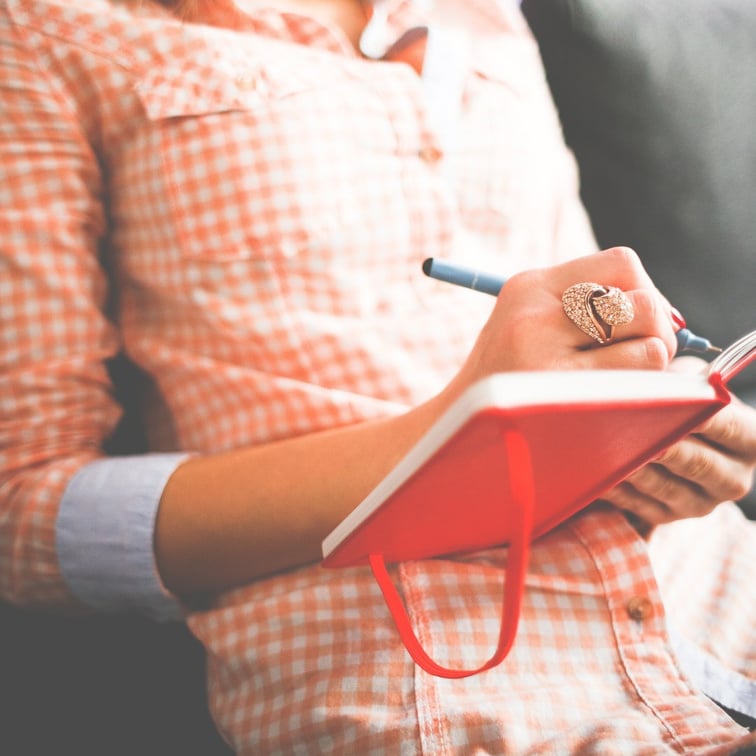 Person Writing on a Journal Notebook